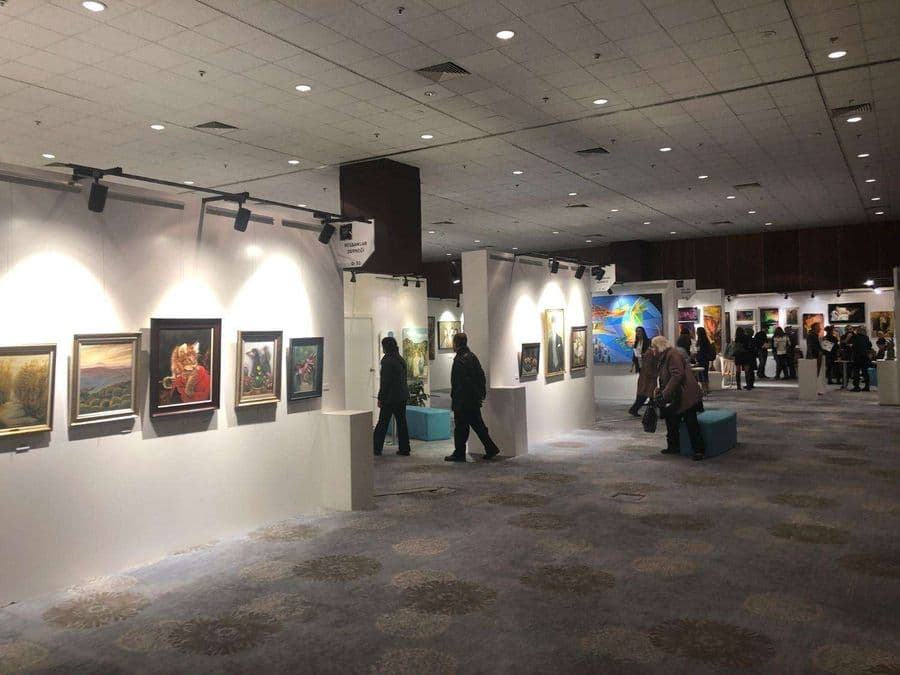 a group of people in a room with art on the wall