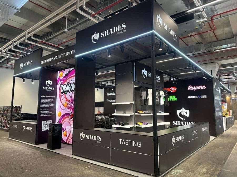 "Chillma Tobacco" markasının şık ve modern fuar standı. Siyah metal iskeletli ve led ışıklandırmalı standın önünde "Tasting" (Tadım) alanı bulunurken, arka duvarda meyvelerle süslenmiş bir kadın portresi yer alıyor.