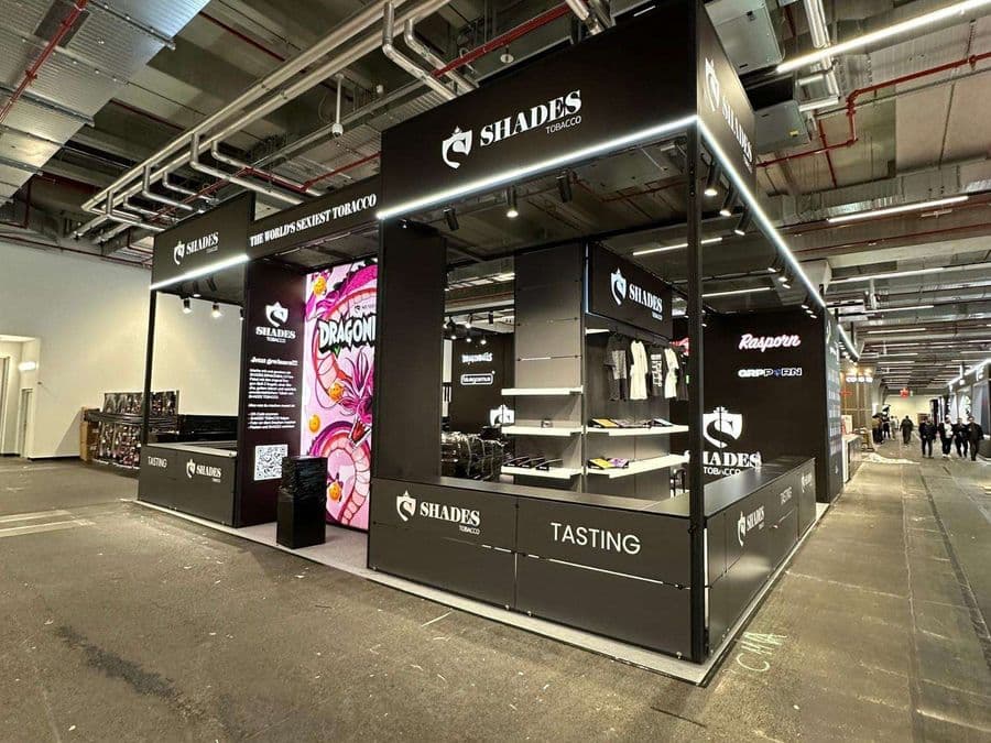 "Chillma Tobacco" markasının şık ve modern fuar standı. Siyah metal iskeletli ve led ışıklandırmalı standın önünde "Tasting" (Tadım) alanı bulunurken, arka duvarda meyvelerle süslenmiş bir kadın portresi yer alıyor.